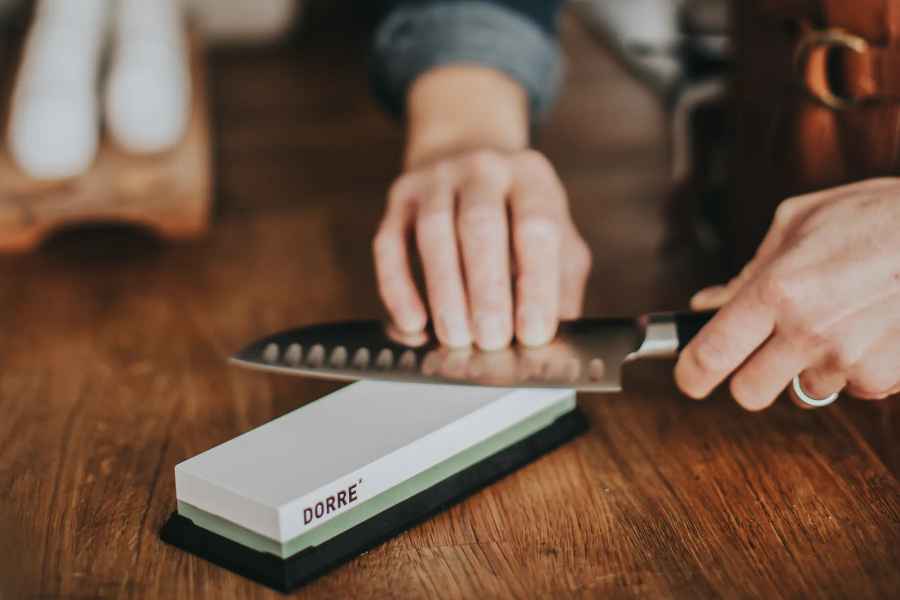 Slipsten och en santoku som slipas på ett träbord